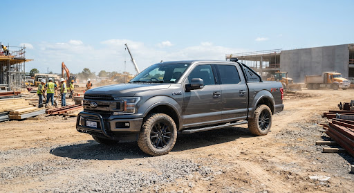 A rugged grey pickup truck on a construction site.